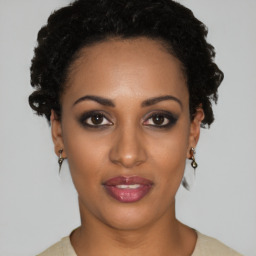 Joyful black young-adult female with short  black hair and brown eyes