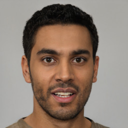 Joyful latino young-adult male with short  brown hair and brown eyes