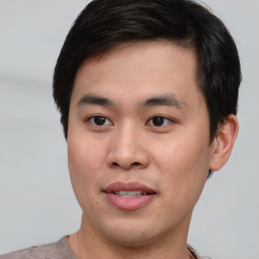 Joyful asian young-adult male with short  brown hair and brown eyes