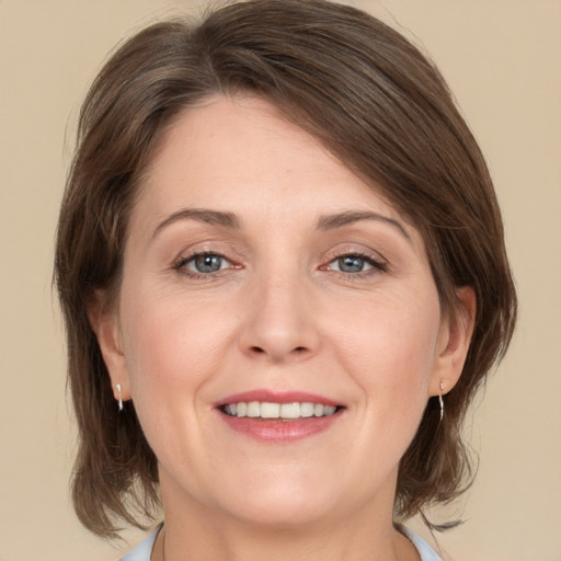 Joyful white adult female with medium  brown hair and grey eyes