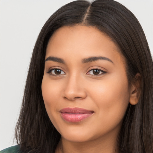 Joyful latino young-adult female with long  brown hair and brown eyes