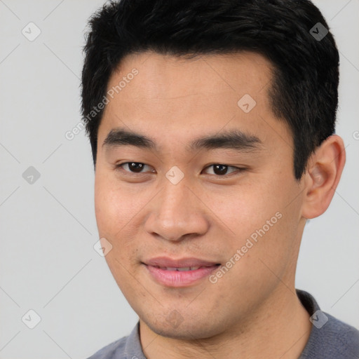 Joyful asian young-adult male with short  black hair and brown eyes