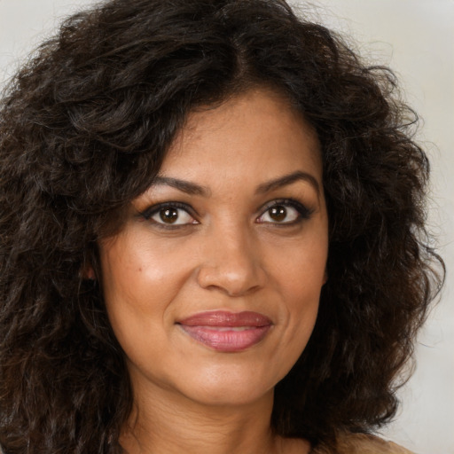 Joyful black young-adult female with long  brown hair and brown eyes