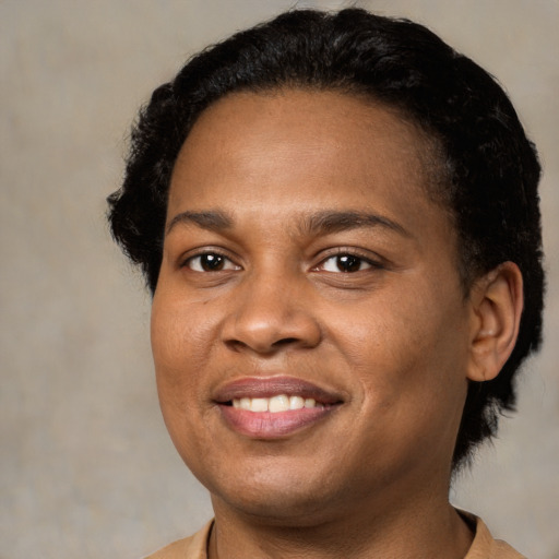 Joyful black young-adult female with short  black hair and brown eyes