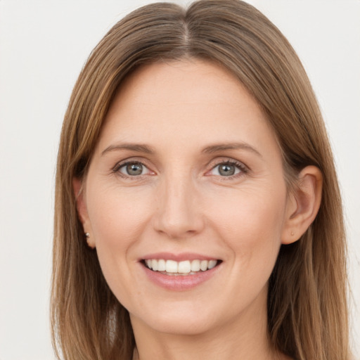 Joyful white young-adult female with long  brown hair and grey eyes