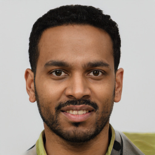 Joyful black young-adult male with short  black hair and brown eyes