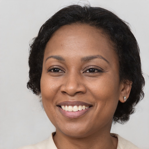 Joyful black adult female with medium  brown hair and brown eyes