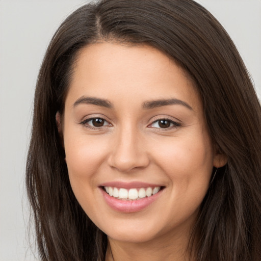 Joyful white young-adult female with long  brown hair and brown eyes