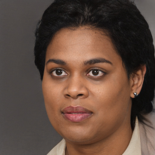 Joyful black young-adult female with short  black hair and brown eyes