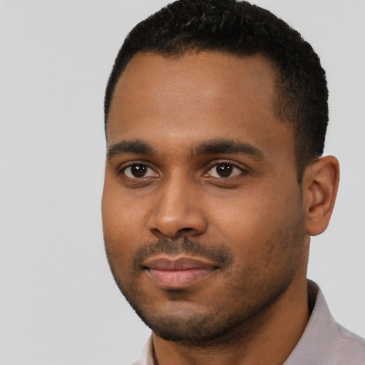 Joyful black young-adult male with short  black hair and brown eyes