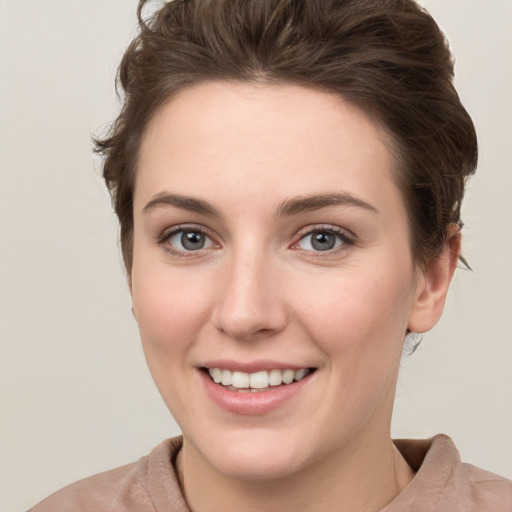 Joyful white young-adult female with short  brown hair and grey eyes