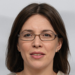 Joyful white adult female with medium  brown hair and grey eyes