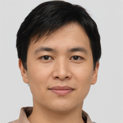 Joyful asian young-adult male with short  black hair and brown eyes