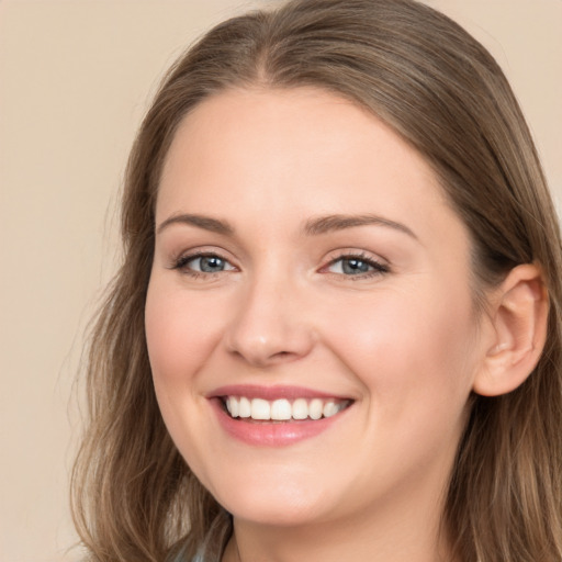 Joyful white young-adult female with long  brown hair and grey eyes