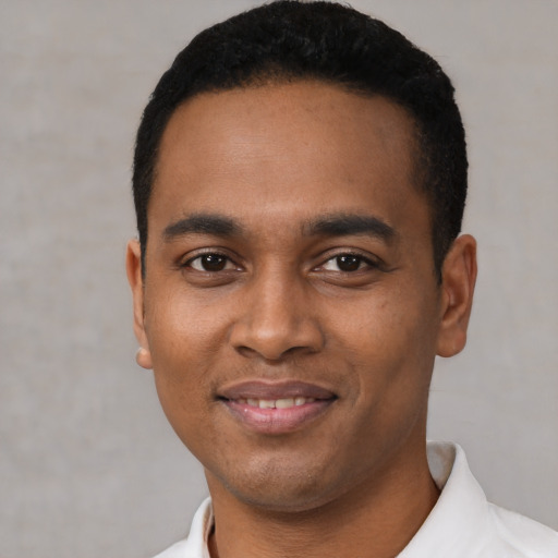 Joyful latino young-adult male with short  black hair and brown eyes