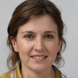 Joyful white young-adult female with medium  brown hair and grey eyes