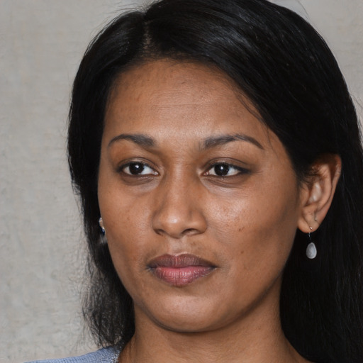 Joyful black young-adult female with long  black hair and brown eyes