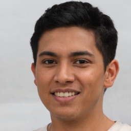 Joyful latino young-adult male with short  brown hair and brown eyes