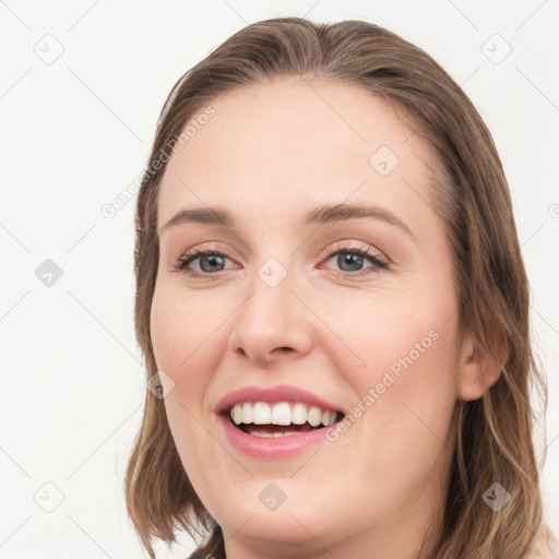 Joyful white young-adult female with long  brown hair and blue eyes