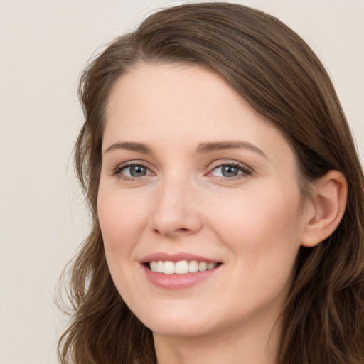 Joyful white young-adult female with long  brown hair and grey eyes