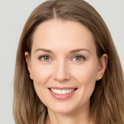 Joyful white young-adult female with long  brown hair and grey eyes