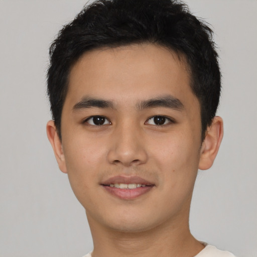 Joyful latino young-adult male with short  brown hair and brown eyes