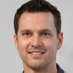 Joyful white adult male with short  brown hair and brown eyes