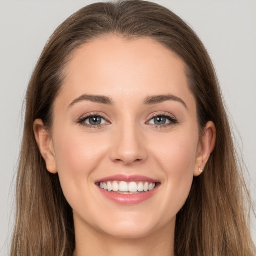 Joyful white young-adult female with long  brown hair and grey eyes