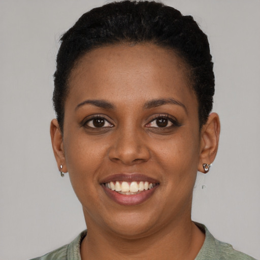 Joyful black young-adult female with short  brown hair and brown eyes