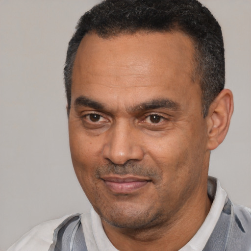 Joyful latino adult male with short  black hair and brown eyes