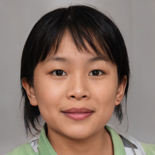 Joyful asian child female with medium  brown hair and brown eyes
