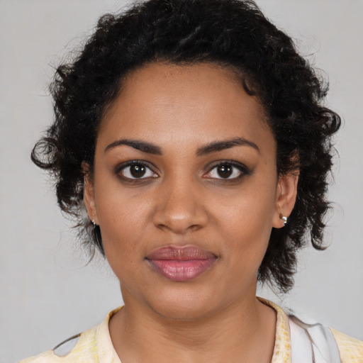 Joyful black young-adult female with medium  black hair and brown eyes