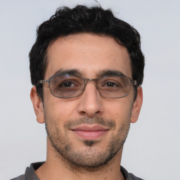 Joyful white young-adult male with short  black hair and brown eyes