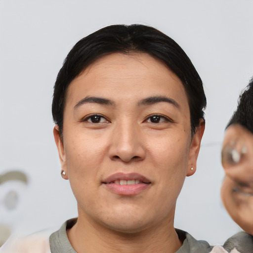Joyful asian young-adult female with short  black hair and brown eyes