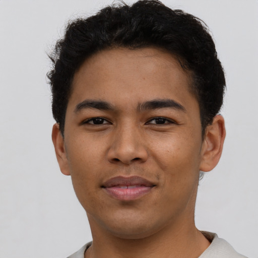 Joyful latino young-adult male with short  brown hair and brown eyes