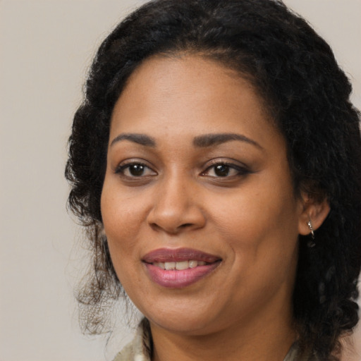 Joyful black adult female with long  brown hair and brown eyes