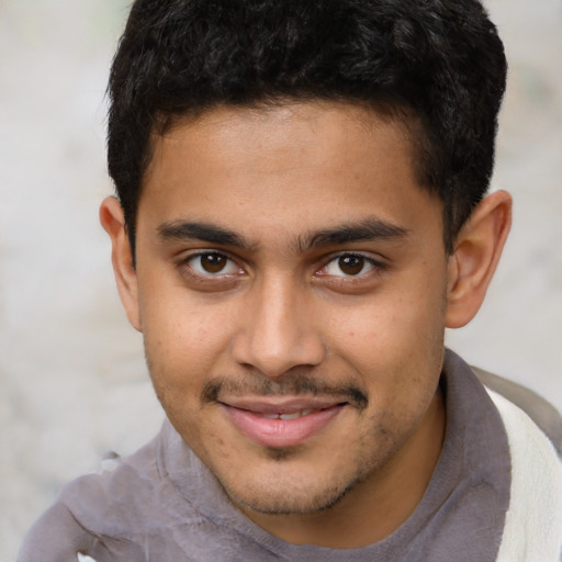 Joyful latino young-adult male with short  brown hair and brown eyes