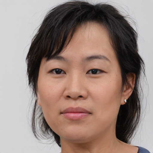 Joyful asian adult female with medium  brown hair and brown eyes