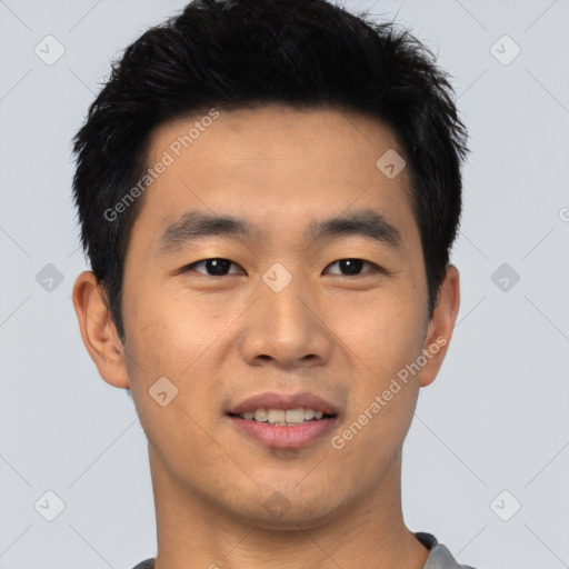 Joyful asian young-adult male with short  black hair and brown eyes