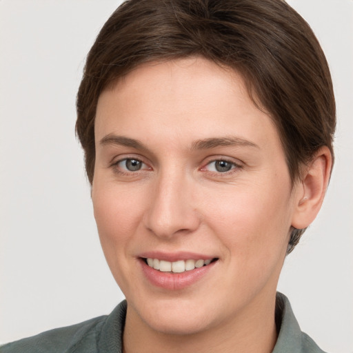 Joyful white young-adult female with short  brown hair and grey eyes