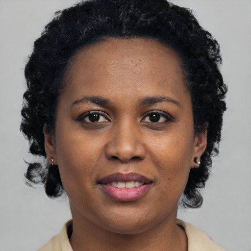 Joyful black young-adult female with short  black hair and brown eyes