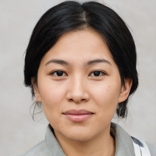 Joyful asian young-adult female with medium  black hair and brown eyes