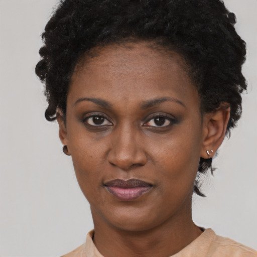 Joyful black young-adult female with short  black hair and brown eyes
