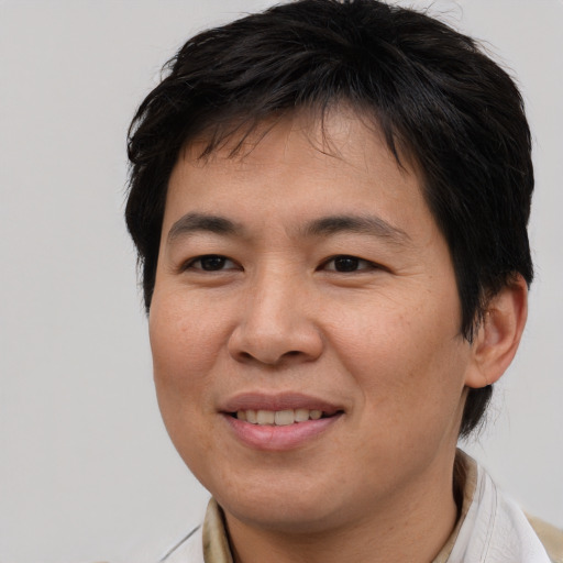 Joyful asian young-adult male with short  brown hair and brown eyes