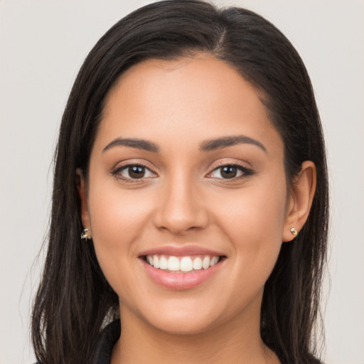 Joyful latino young-adult female with long  brown hair and brown eyes