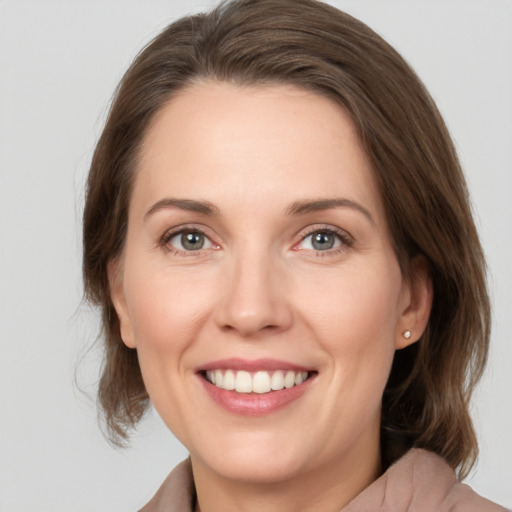 Joyful white young-adult female with medium  brown hair and grey eyes