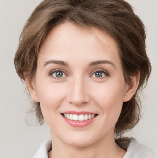 Joyful white young-adult female with medium  brown hair and green eyes