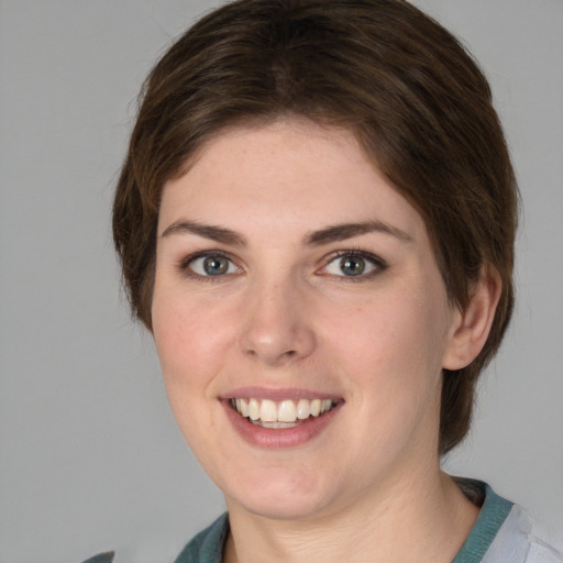 Joyful white young-adult female with medium  brown hair and green eyes