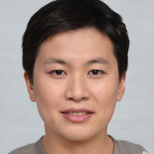 Joyful asian young-adult male with short  brown hair and brown eyes