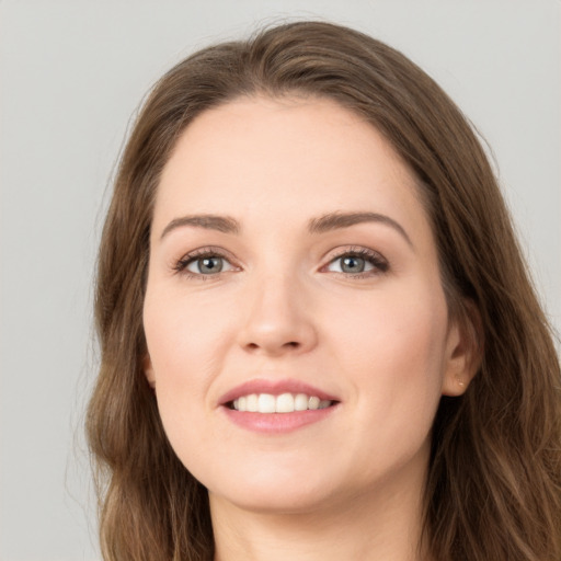 Joyful white young-adult female with long  brown hair and green eyes